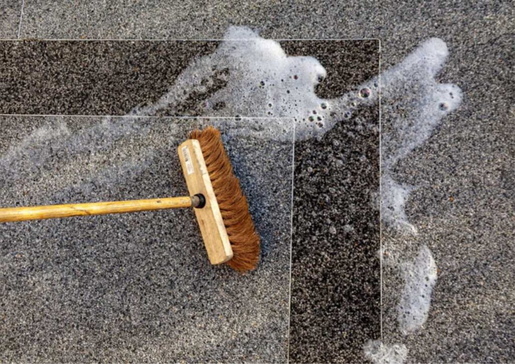 balai et savon sur moquette de pierre sale